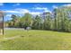 Expansive backyard featuring a shed, bordered by mature trees, and a white fence for privacy at 1077 Williams-White Rd, Zebulon, NC 27597