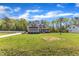 Spacious lawn showcasing a gray two-story home with classic architecture and beautiful landscaping at 1077 Williams-White Rd, Zebulon, NC 27597