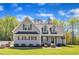 Charming two-story home with gray siding, a black roof, and well-manicured landscaping at 1077 Williams-White Rd, Zebulon, NC 27597