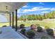 Covered front porch with wooden columns, overlooking a green lawn and landscaped garden beds at 1077 Williams-White Rd, Zebulon, NC 27597