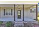 Inviting front porch with wooden columns, a hanging light fixture, and a brick-lined step entrance at 1077 Williams-White Rd, Zebulon, NC 27597