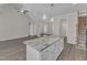 Open floor plan showcases hardwood floors, a kitchen island with granite top, pendant lights, and stairs at 1077 Williams-White Rd, Zebulon, NC 27597