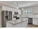 Modern kitchen with white cabinets, granite countertops, stainless steel appliances, and decorative pendant lighting at 1077 Williams-White Rd, Zebulon, NC 27597