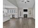 Open-concept living room with vaulted ceilings, a fireplace, and hardwood floors is connected to kitchen at 1077 Williams-White Rd, Zebulon, NC 27597