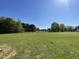 Large flat backyard with newly planted grass and mature trees in the distance at 108 Pate Landing Dr, Selma, NC 27576