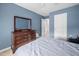 Blue-walled bedroom showcases wood dresser and an open doorway at 1103 Kudzu St, Durham, NC 27713