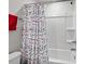 Close-up on bathtub-shower combo with white enclosure and colorful polka-dot shower curtain at 1110 Bent Willow Dr, Durham, NC 27704