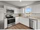 Modern kitchen with white cabinets, stainless steel appliances, and ample counter space for food preparation at 1110 Bent Willow Dr, Durham, NC 27704