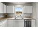 Bright kitchen featuring white cabinets, stainless steel appliances, and a well-lit countertop area at 1110 Bent Willow Dr, Durham, NC 27704