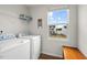 Functional laundry area with modern washer and dryer, storage, and natural light from a window at 1110 Bent Willow Dr, Durham, NC 27704
