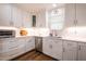 Bright and modern kitchen with stainless steel appliances, light countertops, and white cabinets at 112 Red Admiral Ct, Hillsborough, NC 27278