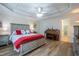 This main bedroom has a decorative tray ceiling with ceiling fan, wood floors and access to the main bathroom at 112 Red Admiral Ct, Hillsborough, NC 27278