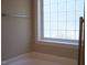 Bathroom featuring a clear glass block window above a bathtub with a chrome towel rack at 1215 Agile Dr, Knightdale, NC 27545