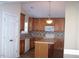 Well-equipped kitchen featuring wood cabinets, an island, tile backsplash, and modern appliances at 1215 Agile Dr, Knightdale, NC 27545