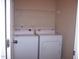 A laundry room features a white washer and dryer and storage space with a metal rack above at 1215 Agile Dr, Knightdale, NC 27545