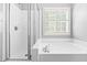Bright white bathroom featuring a tub and shower combo at 12325 Inglehurst Dr, Raleigh, NC 27613