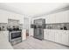 Well-equipped kitchen with stainless steel appliances, white cabinets, and tile flooring at 12325 Inglehurst Dr, Raleigh, NC 27613