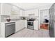 Modern kitchen featuring stainless steel appliances, white cabinets, and stylish backsplash at 12325 Inglehurst Dr, Raleigh, NC 27613