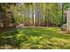 Expansive backyard featuring a well-manicured lawn, mature trees, and a storage shed, providing ample space at 125 Kelekent Ln, Cary, NC 27518