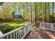 A beautifully landscaped backyard with a wood deck and lush green lawn offers a serene outdoor retreat at 125 Kelekent Ln, Cary, NC 27518