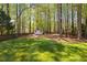 Spacious backyard with lush lawn and wooded surroundings, providing a private and peaceful outdoor setting at 125 Kelekent Ln, Cary, NC 27518