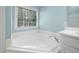Bright bathroom displays soaking tub under window with neutral wall paint and white trim throughout at 125 Kelekent Ln, Cary, NC 27518