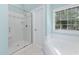 Bathroom boasts a tiled walk-in shower, soaking tub beneath the window, and neutral wall colors at 125 Kelekent Ln, Cary, NC 27518