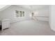 Bright bonus room with neutral carpet, natural light and staircase access to another level at 125 Kelekent Ln, Cary, NC 27518