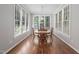 Dining room with wood table, four chairs, hardwood floors, and windows all around at 125 Kelekent Ln, Cary, NC 27518