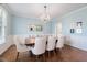 Dining room boasts a chandelier, light blue walls, hardwood floors, and a large wood table with upholstered chairs at 125 Kelekent Ln, Cary, NC 27518