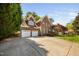 Traditional two-story brick home with a three-car garage and well-manicured lawn offers curb appeal at 125 Kelekent Ln, Cary, NC 27518