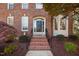 Close-up of the home's entryway featuring a black front door, brick steps, and manicured landscaping at 125 Kelekent Ln, Cary, NC 27518