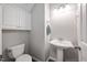 Half bathroom with toilet, pedestal sink, storage cabinet and neutral paint at 125 Kelekent Ln, Cary, NC 27518