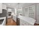 Bright kitchen with a large island, stainless appliances, and views from the surrounding windows at 125 Kelekent Ln, Cary, NC 27518