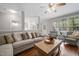 Cozy living room featuring a sectional sofa, accent chairs, hardwood floors, and large windows at 125 Kelekent Ln, Cary, NC 27518