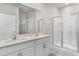 A bathroom with a double vanity, quartz countertop, walk-in shower, and chrome fixtures at 128 Pisgah St, Sanford, NC 27330