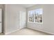 Bright bedroom featuring neutral carpet, a window with a view of the neighborhood, and a gray wall at 128 Pisgah St, Sanford, NC 27330