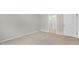 A bedroom featuring neutral carpet, gray walls, and a door leading to the bathroom at 128 Pisgah St, Sanford, NC 27330