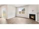 Bright living room showcases a cozy fireplace, large window and sliding glass doors to the patio at 128 Pisgah St, Sanford, NC 27330