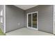 Covered patio with gray siding and concrete floor, accessible through sliding glass door at 128 Pisgah St, Sanford, NC 27330