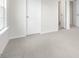 An open bedroom with carpet, white walls, white trim, and several white doors throughout at 129 Pisgah St, Sanford, NC 27330