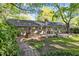 Backyard with a wooden deck, mature trees, brick pathway, and inviting outdoor space at 1304 Deboy St, Raleigh, NC 27606
