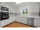 White kitchen with stainless-steel appliances and hard wood floors at 1304 Deboy St, Raleigh, NC 27606