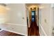 Hallway with hardwood floors and white trim leads to bedrooms and other areas of the home at 1308 Oakridge Ave # 3, Henderson, NC 27536