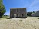 Backyard with a gray house, open space and ready for landscaping at 136 Baneberry Pl, Broadway, NC 27505