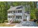 Charming two-story home features a white exterior with black shutters, surrounded by mature trees at 14 W Bridlewood Trl, Durham, NC 27713