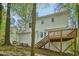 Charming exterior view showcasing a spacious deck, and white siding surrounded by lush trees at 14 W Bridlewood Trl, Durham, NC 27713