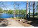 A concrete boat ramp leading into the lake, surrounded by mature trees and lush greenery at 150 Big Horn Cv, Louisburg, NC 27549