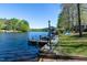 Picturesque lake scene featuring a private dock with boat access and scenic waterfront views at 150 Big Horn Cv, Louisburg, NC 27549