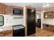 Compact kitchen featuring modern appliances, wood cabinetry, and seamless integration with the living space at 150 Big Horn Cv, Louisburg, NC 27549